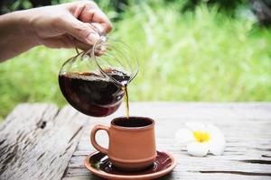 man die infuus verse koffie maakt in vintage coffeeshop met groene natuur achtergrond - mensen met verse koffie in de natuur concept foto