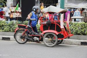 Yogyakarta, Indonesië - mei 2022 bentor - becak motor op Malioboro Street, unieke gemodificeerde motorfiets met fietstaxi. foto