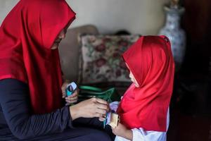 Indonesische mensentraditie tijdens eid mubarak-viering van het verdelen van geld of riep thr. aziatische moslimvrouw geeft geld aan schattige jongen van familie tijdens idul fitri. foto