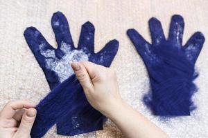 vakman voegt vezels toe aan de achterkant van de handschoen foto