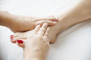 vrouw die voetmassage krijgt van masseuse close-up bij hand en voet - ontspan in voetmassage therapie dienstverleningsconcept foto