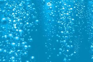 defocus wazig transparant blauw gekleurd helder kalm water oppervlaktetextuur met spatten en bubbels. bubbelwater onder de zee. waterschuim onder de oceaan. blauwe aquarel met schuim en bubbels. foto