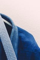 close-up op Braziliaans jiu jitsu of judo blauw kimono-uniform dat naast een muur hangt foto