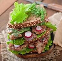 sandwich met vlees, groenten en plakjes roggebrood foto