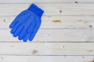 blauwe handschoenen op houten achtergrond foto