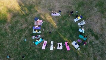 groep vrouwen die samen yoga uitoefenen in het openbare park bij zonsondergang van de hete zomer, luchtfoto hoge hoekmening van wardown park luton engeland uk foto