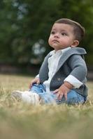 schattige kleine baby baby poseert in een plaatselijk openbaar park in de stad Luton in Engeland foto
