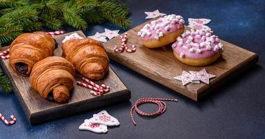 krokante chocoladecroissant met kerstversiering op houten snijplank foto