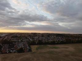 prachtige zonsondergang boven de britse stad, kleurrijke lucht met gele, oranje en zwarte wolken boven lichtblauwe lucht foto