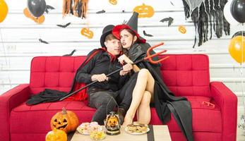 gelukkig halloween-feestconcept. jonge man en vrouw die als vampieren, heks of geest dragen, vieren het halloween-festival foto