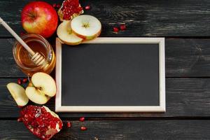 Rosj Hasjana viering. honing, appels en granaatappels op donkere houten achtergrond. frame voor felicitatietekst. joodse traditionele religieuze feestdag. foto