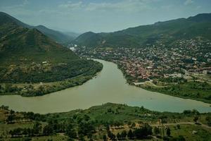 georgië, mtskheta, samenvloeiing van de aragvi en kura, mtkvari, rivieren en de stad mtskheta vanaf de top van de jvari-berg, daglichtweergave. foto