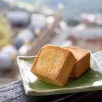 heerlijk ananasgebak in een bord voor afternoontea op houten balustrade van een theehuis in taiwan met een prachtig landschap op de achtergrond, close-up. foto