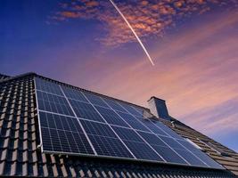 zonnepanelen die schone energie produceren op een dak van een woonhuis foto