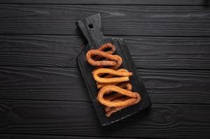 zelfgemaakte churros op een houten zwarte achtergrond. foto