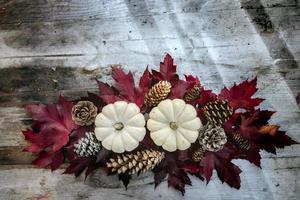 feestelijk herfstdecor van pompoenen, dennen en bladeren op een houten ondergrond. concept van thanksgiving day of halloween. plat lag herfstcompositie met kopieerruimte. foto