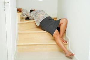 Aziatische dame vrouw verwondingen door vallen op gladde oppervlakken trappen thuis. foto