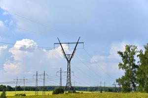 hoogspanningsleidingen en een stormachtig landschap in een geel veld in de zomer. foto