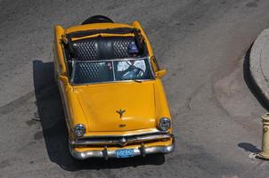 havana, cuba - 29 juni 2019 - luchtfoto van een gele klassieke auto die linksaf slaat in de stad havana, cuba. foto