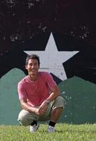 jonge man zit voor een achtergrond met een grote ster erop geschilderd foto