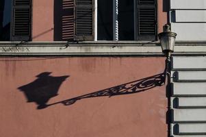 straatlantaarn die een lange schaduw werpt tijdens zonsondergang in rome, italië foto