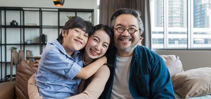 portret van een gelukkige Aziatische familie die samen tijd doorbrengt op de bank in de woonkamer. familie en huis concept. foto