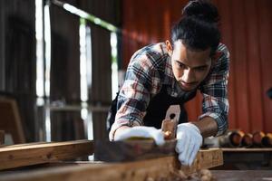 jonge aziatische man timmerman aan het werk in houtbewerking timmerwerkplaats. foto