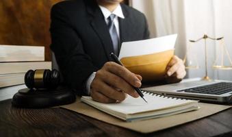 zaken en advocaten bespreken contractpapieren met koperen schaal op bureau in kantoor. wet, juridische diensten, advies, rechtvaardigheid en wet concept foto met film grain effect