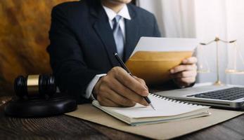 zaken en advocaten bespreken contractpapieren met koperen schaal op bureau in kantoor. wet, juridische diensten, advies, rechtvaardigheid en wet concept foto met film grain effect