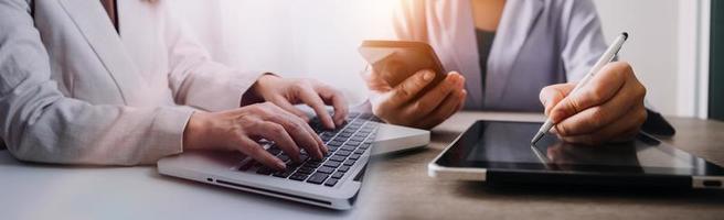 zakenman die creditcard en rekenmachine gebruikt om online te winkelen, selectieve aandacht. foto