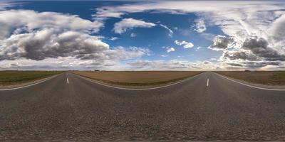 volledig bolvormig naadloos panorama 360 graden hoekzicht op asfaltweg zonder verkeer tussen velden in de avond voor zonsondergang met bewolkte hemel. 360 panorama in equirectangular projectie, vr ar inhoud foto