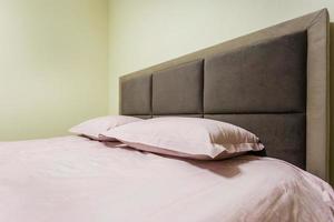 tweepersoonsbed met kussens in het interieur van de moderne intieme slaapkamer in een loft in appartementen in lichte kleurstijl foto