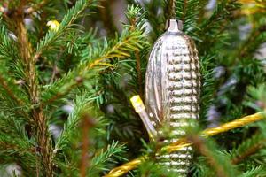 glazen kegel in twijgen van natuurlijke kerstboom foto