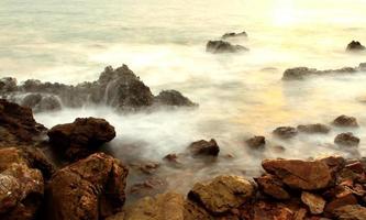 prachtig zeegezicht. zee en rots bij de zonsondergang foto