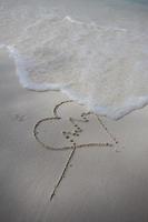 harten getekend op het zand van een strand foto