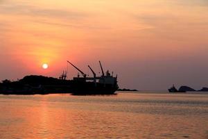 vrachtschip in de haven bij zonsondergang foto