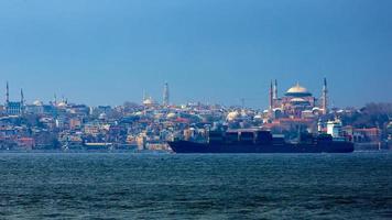 containerschip in de Bosporus met op de achtergrond Hagia Sophia. Istanbul, Turkije. foto