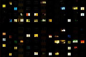 plat nachtpanorama van veelkleurig licht in ramen van gebouwen met meerdere verdiepingen. leven in de grote stad foto