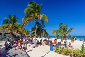 mensen op het zandstrand met kokospalmen in playa del carmen, yukatan, mexico foto