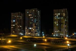 nachtpanorama van licht in de ramen van een gebouw met meerdere verdiepingen. leven in een grote stad foto