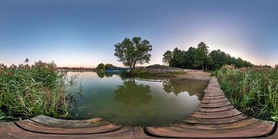 volledig naadloos bolvormig hdri-panorama 360 graden hoekzicht op houten pier van enorm meer of rivier in de ochtend met roze zonsopgang met mistmist in equirectangular projectie, vr-inhoud foto