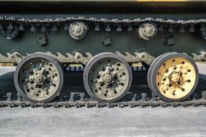 rupsbanden en wielen van tank, gepantserde voertuigen op straat in groene kaki kleur foto
