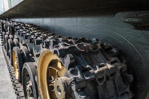 rupsbanden en wielen van tank, gepantserde voertuigen op straat in groene kaki kleur foto