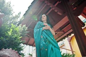 portret van mooie Indiase brumette meisje of hindoe vrouw model tegen japans traditioneel huis. foto