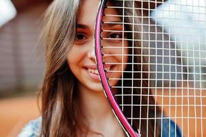 jonge sportieve meisjesspeler met tennisracket op tennisbaan. foto