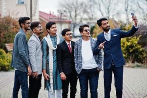 groep van zes zuid-aziatische indiaan mans in traditionele, casual en zakelijke kleding die staat en samen selfie maakt op mobiele telefoon. foto