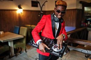 mode Afro-Amerikaanse man model dj op rood pak met dj-controller. foto