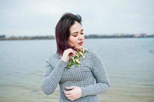 portret van brunette meisje in grijze jurk achtergrond het meer. foto