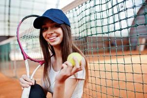 jonge sportieve meisjesspeler met tennisracket op tennisbaan. foto