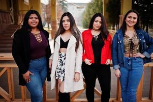 groep van vier gelukkige en mooie latino-meisjes uit ecuador poseerden op straat. foto